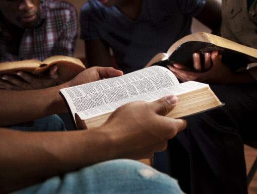 Young adults meeting together in a Bible study.  Focus on the Open Bible.