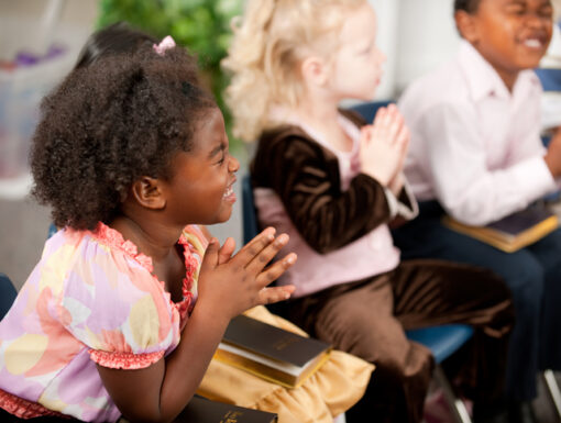 A group of multi-ethnic children at Sunday School in a real church classroom. Very shallow focus. Selective focus on girl closest to the camera